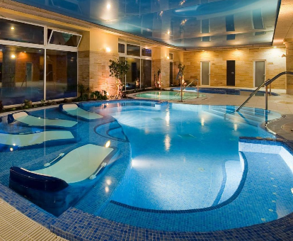 Fotografía de la piscina cubierta con tumbonas dentro del agua que se encuerta en el Elba Estepona Gran Hotel & Thalasso Spa
