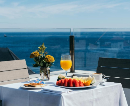 Foto de la terraza con desayuno en la mesa y vistas a la playa del Gran Hotel Victoria
