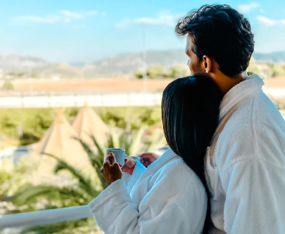 Foto de una pareja mirando al horizonte de un paisaje panorámico desde la terraza de su habitación en el hotel HO Ciudad de Jaén
