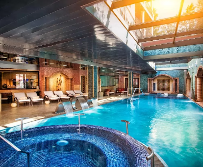 Foto de la piscina cubierta, con bañera de hidromasaje y tumbonas del Hotel Cala del Pi