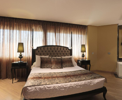Foto de una cama con grandes ventanales detrás del Hotel Condestable Iranzo

