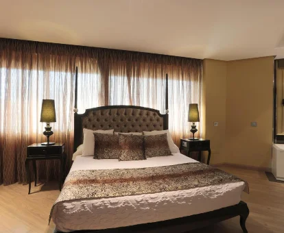Foto de una cama con grandes ventanales detrás del Hotel Condestable Iranzo 
