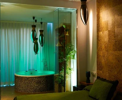 Foto de la habitación con bañera de hidromasaje al lado de la cama que se encuentra en el Hotel Gabbeach 
