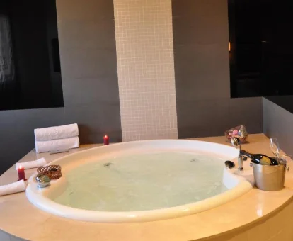 Foto del jacuzzi redondo, con chorros de agua, valas aromáticas y una botella de champán que se encuentra en el Hotel Los Peñascales - Adults Only