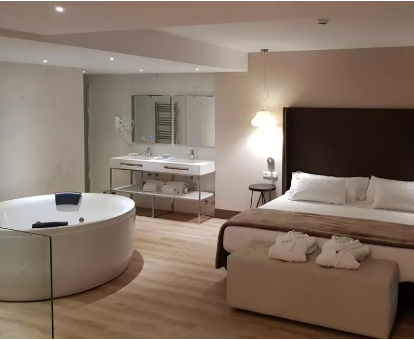 Foto de la habitación con jacuzzi al lado de la cama del Hotel Maria Cristina
