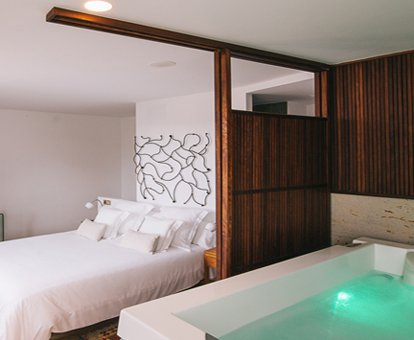 Foto de la habitación con jacuzzi al lado de la cama del Hotel Quercus Tierra