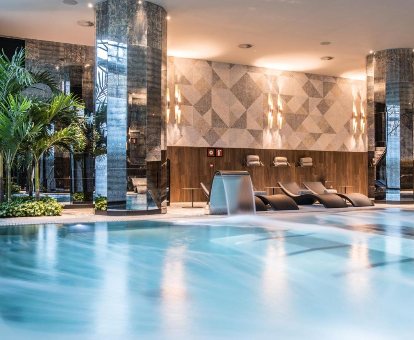 Foto del spa con piscina cubierta, tumbonas y cascada de agua que se encuentra en el Hotel Sofia Barcelona - in The Unbound Collection by Hyatt