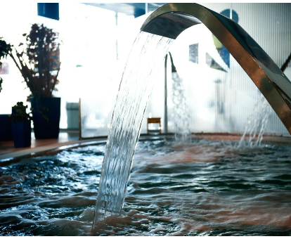 Foto de la piscina cubierta con cascadas de agua que se encuentra en el spa del Hotel Torresport
