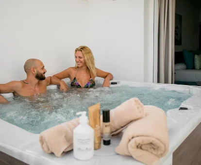 Foto de una pareja en el jacuzzi privado de la Suite del Moon Hotel & SPA. 
