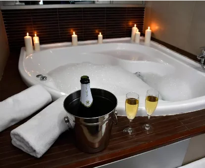 Foto del jacuzzi privado con velas y una botella de champán del hotel Sol Almería 
