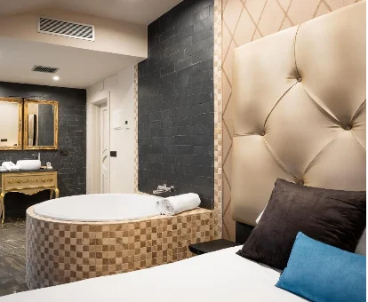 Foto de la habitación con bañera de hidromasaje al lado de la cama del aparthotel Suite 1907 Aviles