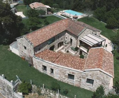 Vista aérea de este precioso hotel rústico con piscina y rodeado de naturaleza.