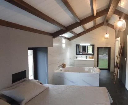 Habitación con gran bañera de hidromasaje privada junto a la cama de este coqueto apartamento independiente.