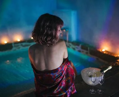 Bañera de hidromasaje privada junto a la cama de una de las casas del alojamiento.