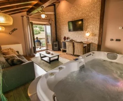 Fabuloso salón con bañera de hidromasaje privada para 2 personas ante la suite del hotel.