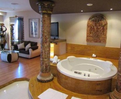 Suite con bañera de hidromasaje redonda y elegante decoración.