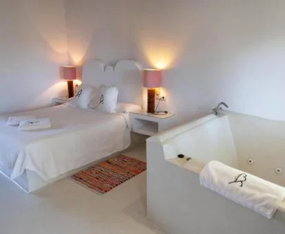 Dormitorio de la Habitación Doble con bañera de hidromasaje cerca de la cama.