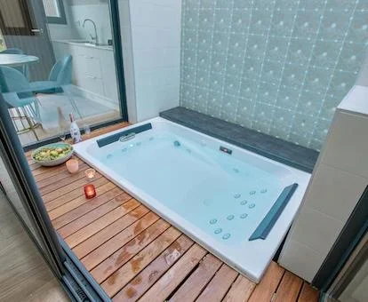 Foto del jacuzzi a ras del suelo para dos personas con un poco de fruta en el borde cerca de la chimenea en el apartamento deluxe en Alto da Pousa