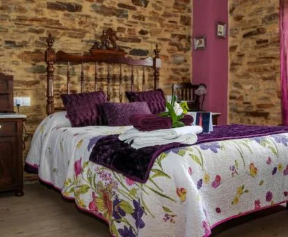 Una de las habitaciones de estilo rústico con paredes de piedra a la vista de este hotel con encanto.