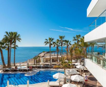 Edificio de este hotel con encanto con amplia piscina, zonas exteriores y vistas al mar.