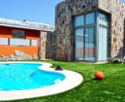 Zona exterior con solarium y piscina privada de una de las villas del complejo.