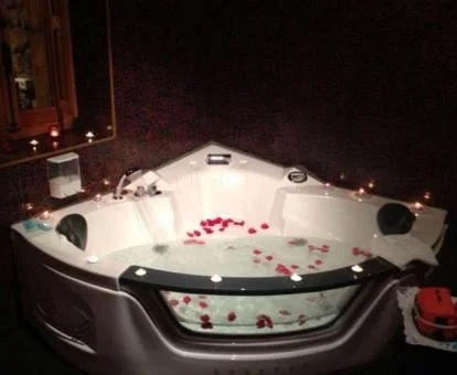 Precioso jacuzzi privado decorado con pétalos de rosa de uno de los apartamentos del complejo.