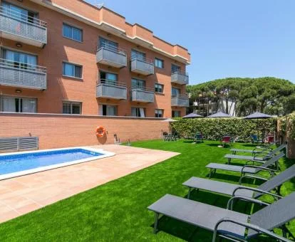Edificio de este complejo de apartamentos con piscina exterior, solarium y jardín.