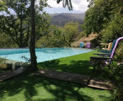 Amplia piscina exterior rodeada de naturaleza con vistas de este complejo de apartamentos.