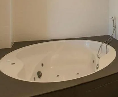 Baño de la Habitación Doble Deluxe con bañera de hidromasaje privada.