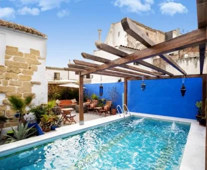 Preciosa terraza con mobiliario y piscina de este establecimiento.