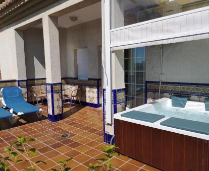Amplia terraza con tumbonas y gran jacuzzi privado de la suite del hotel.