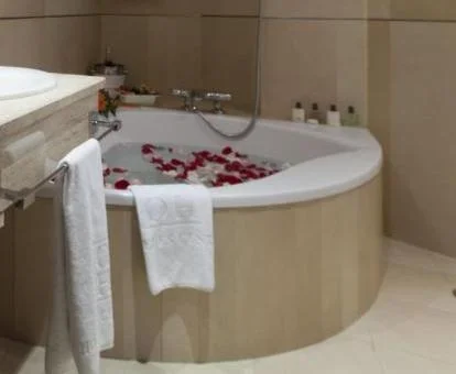 Bañera de hidromasaje privada decorada con pétalos de la Suite Junior.