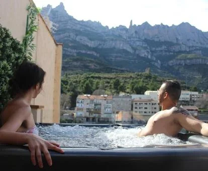 Pareja en el jacuzzi de gran tamaño de la terraza del apartamento Barcelo Esteve con vistas a Montserrat