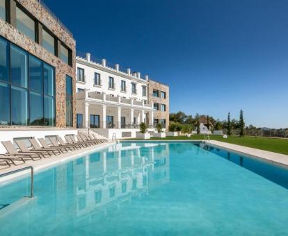 Precioso edificio con gran piscina al aire libre rodeada de jardines de este hotel con encanto.