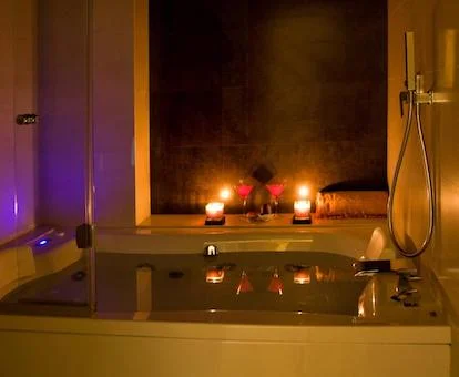 Habitación Doble Superior con bañera de hidromasaje privada cerca de la cama.