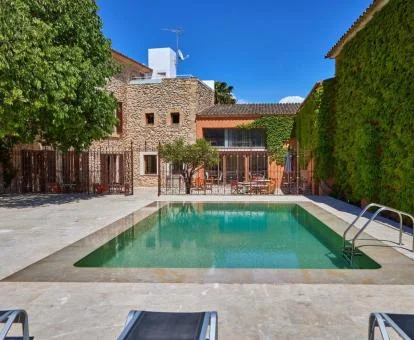 Zona exterior con piscina y mobiliario de este acogedor hotel solo para adultos.