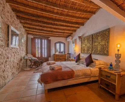 Una de las coquetas habitaciones de estilo rústico con paredes de piedra a la vista del hotel.
