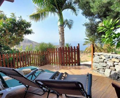 Acogedora terraza con mobiliario rodeada de naturaleza con vistas al mar de esta cabaña independiente.