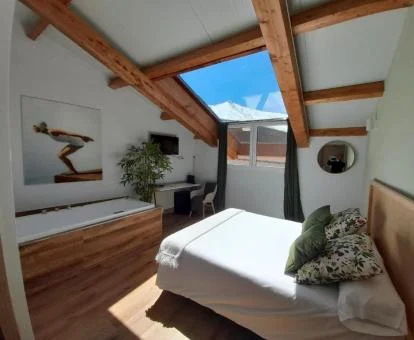 Hermosa habitación con bañera de hidromasaje privada junto a la cama de este hotel con encanto.
