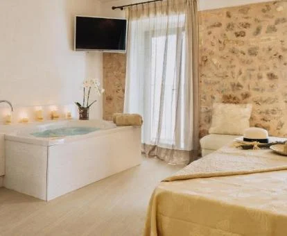 Bañera de hidromasaje privada junto a la cama de la Habitación Doble Deluxe.