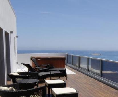 Fabulosa terraza con jacuzzi privado y vistas al mar de la habitación doble deluxe del hotel.