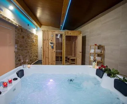 Foto del jacuzzi para cuatro personas en funcionamiento con chorros de hidroterapia y que se encuentra frente a la sauna en el chalet Casa Peña Dura