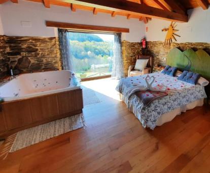 Jacuzzi de forma cuadrada de gran tamaño junto a la cama que se encuentra cerca de la ventana en el Apartamento con suelo y vigas de madera.