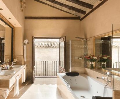 Amplio baño con jacuzzi privado de la Suite 1800 con vistas parciales a la Alhambra.