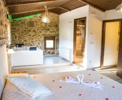 Preciosa suite deluxe con bañera de hidromasaje privada cerca de la cama de este hotel con encanto.