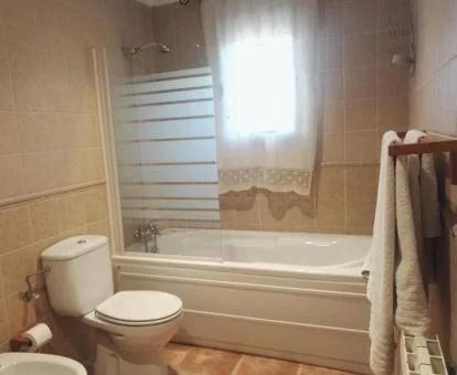 Baño con bañera de hidromasaje privada de la casa de tres dormitorios de este establecimiento.