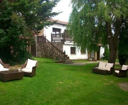 Edificio de este hotel con encanto con amplios jardines y mobiliario al aire libre.