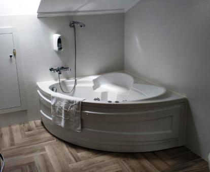 Amplia bañera de hidromasaje privada de la habitación deluxe de cama grande.