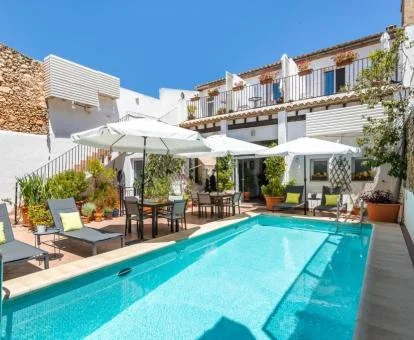 Precioso hotel con encanto con piscina exterior y mobiliario al aire libre.
