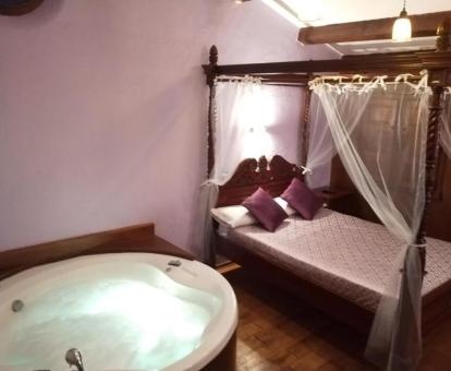 Una de las acogedoras habitaciones con bañera de hidromasaje junto a la cama del hotel.